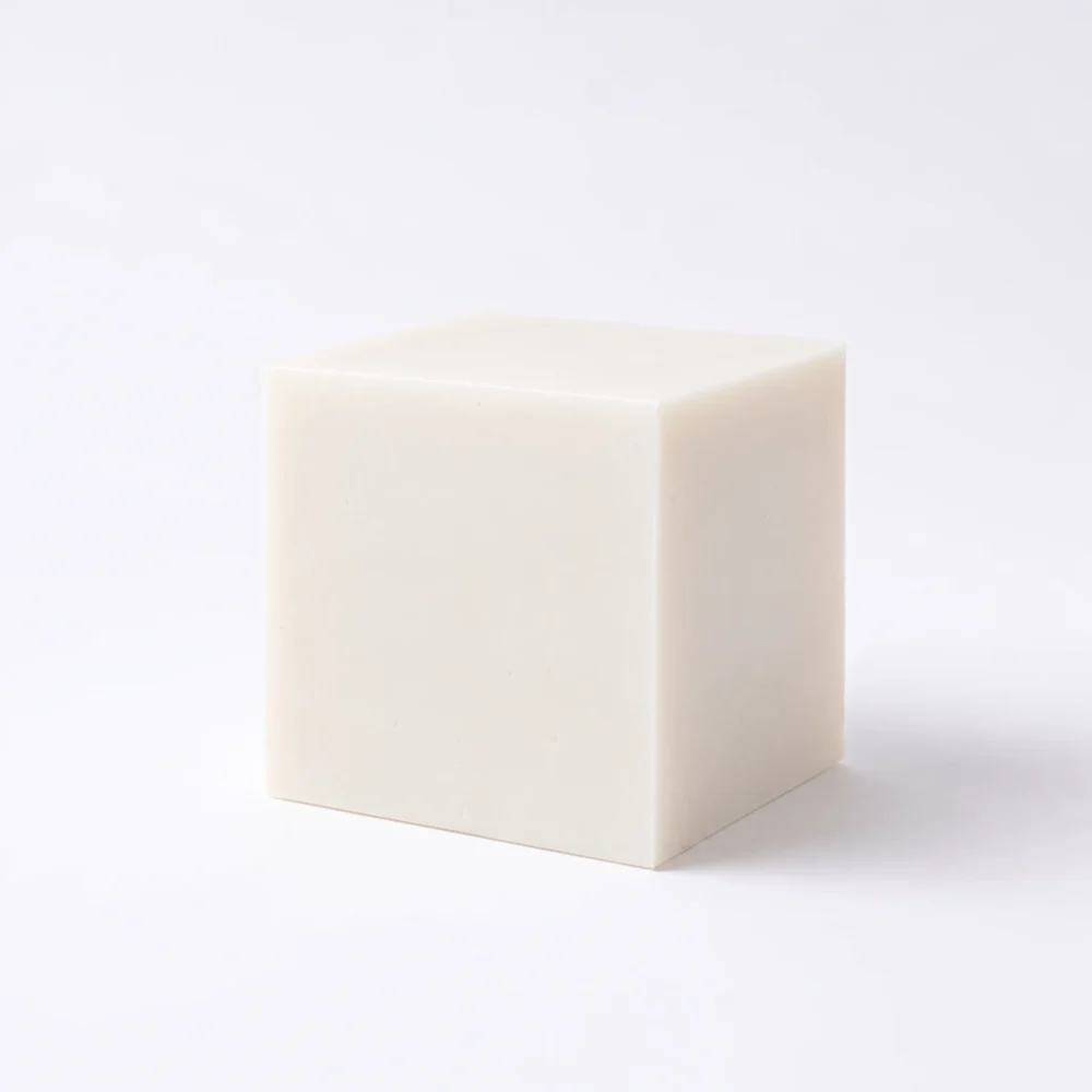 Unlabeled solid dish soap block on a white background